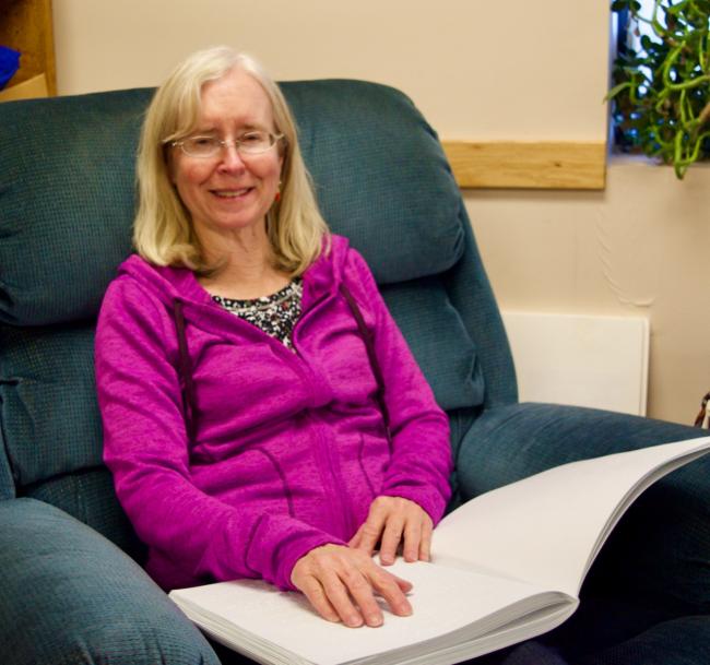 Janet relaxing and reading Braille